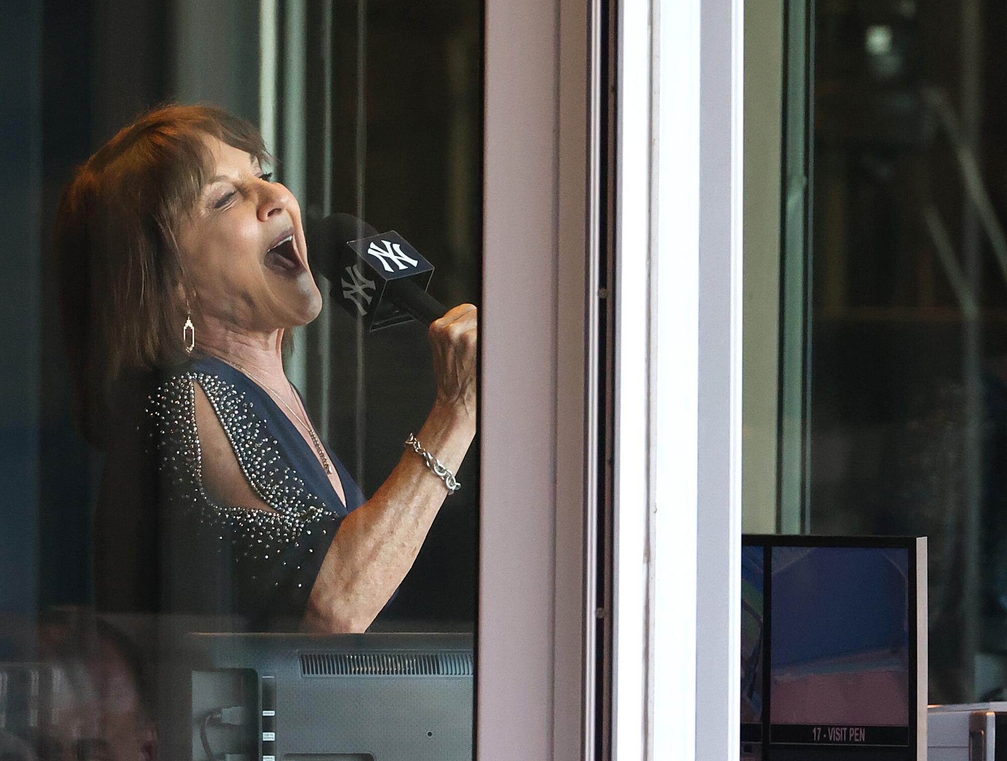 New York Yankees radio announcer Suzyn Waldman sings the national anthem from the broadcasting booth