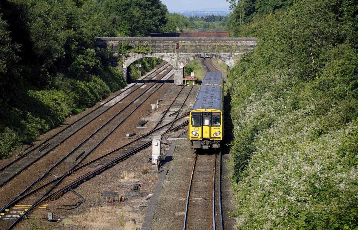 A train pulls into Hunts Cross Station, in Liverpool, England, Monday, June 20, 2022. Unions and train companies in Britain are set to hold last-minute talks Monday amid fading hopes of averting the country’s biggest rail strikes for decades. (Peter Byrne/PA via AP)