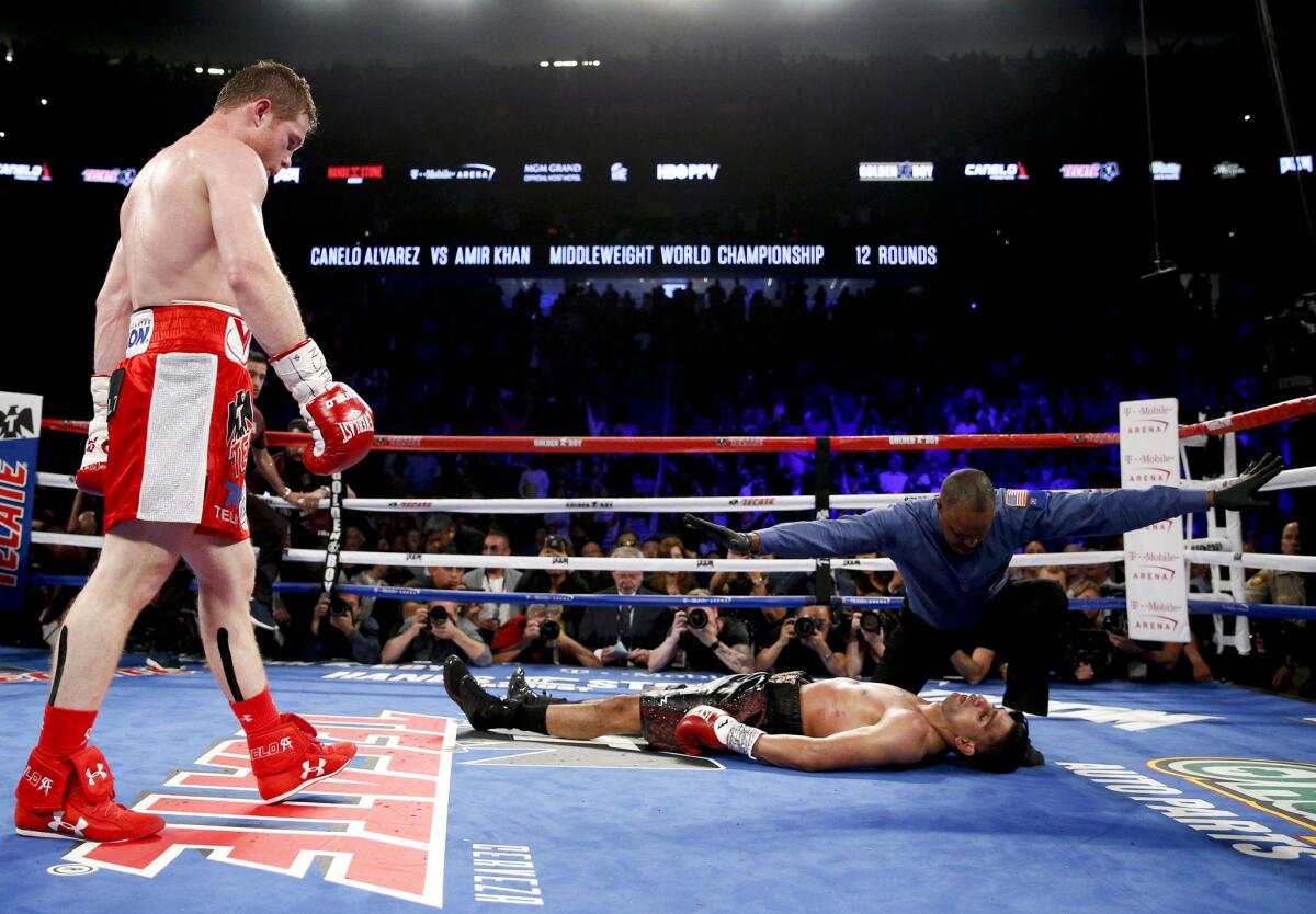 Amir Khan is counted out by the referee after getting knocked out by Canelo Alvarez in the sixth round of their WBC middleweight title fight Saturday at T-Mobile Arena in Las Vegas.