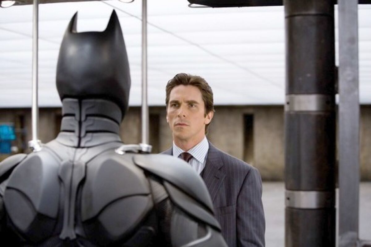 Christian Bale as Bruce Wayne examines the batsuit in 2008's "The Dark Knight."