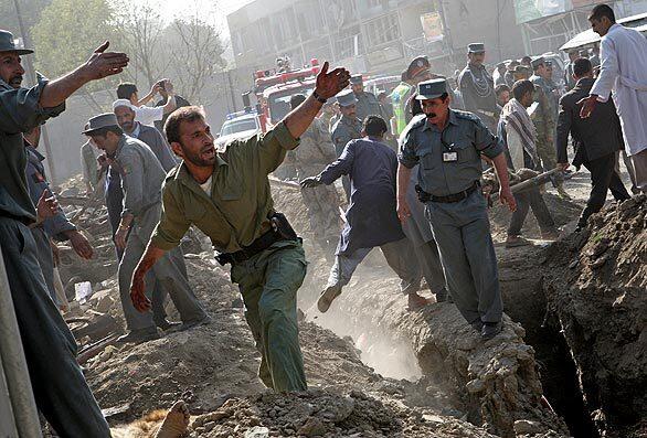 Rescue workers recover a body at the scene of a suicide bombing in Kabul on Thursday. The explosion left 17 people dead and at least 70 injured during what local authorities say was a targeted attack on the Indian Embassy in Kabul.