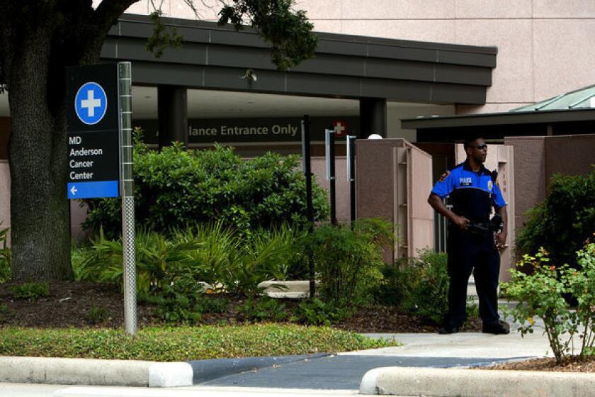 A police officer stands in front of the MD Anderson Cancer Center in Houston, where Delaware Atty. Gen. Beau Biden underwent an undisclosed medical procedure.