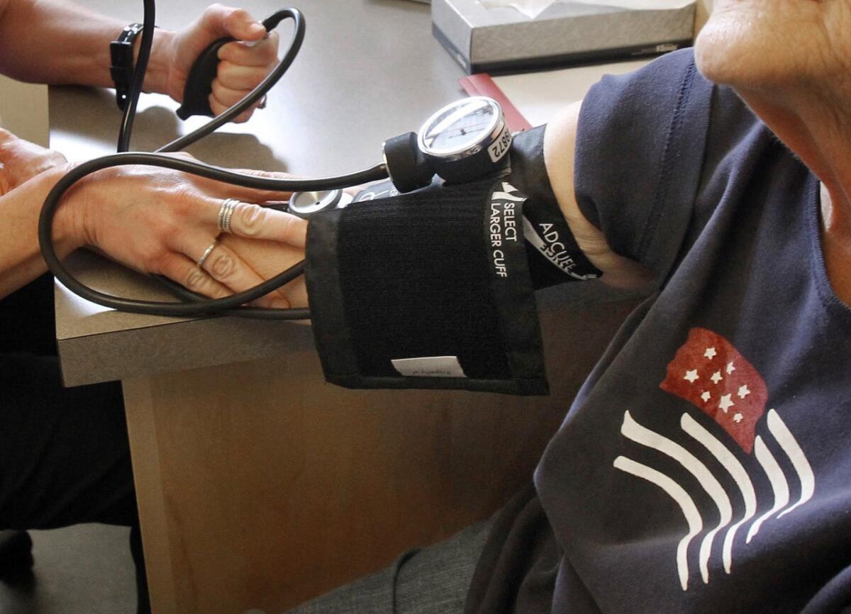 A patient has her blood pressure checked by a registered nurse in Plainfield, Vt. A major new U.S. study shows that treating high blood pressure more aggressively than usual cuts the risk of heart disease and death in people over age 50, the National Institutes of Health said Friday.