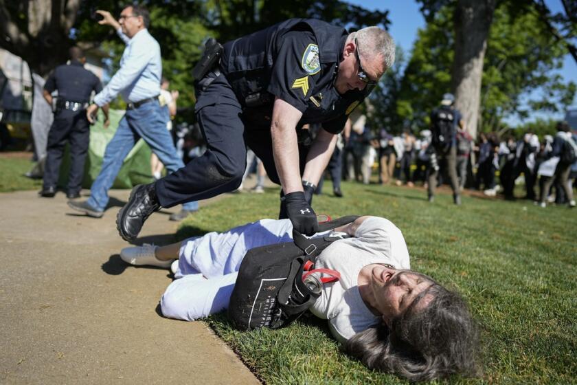 Un agente de la policía detiene a un manifestante 