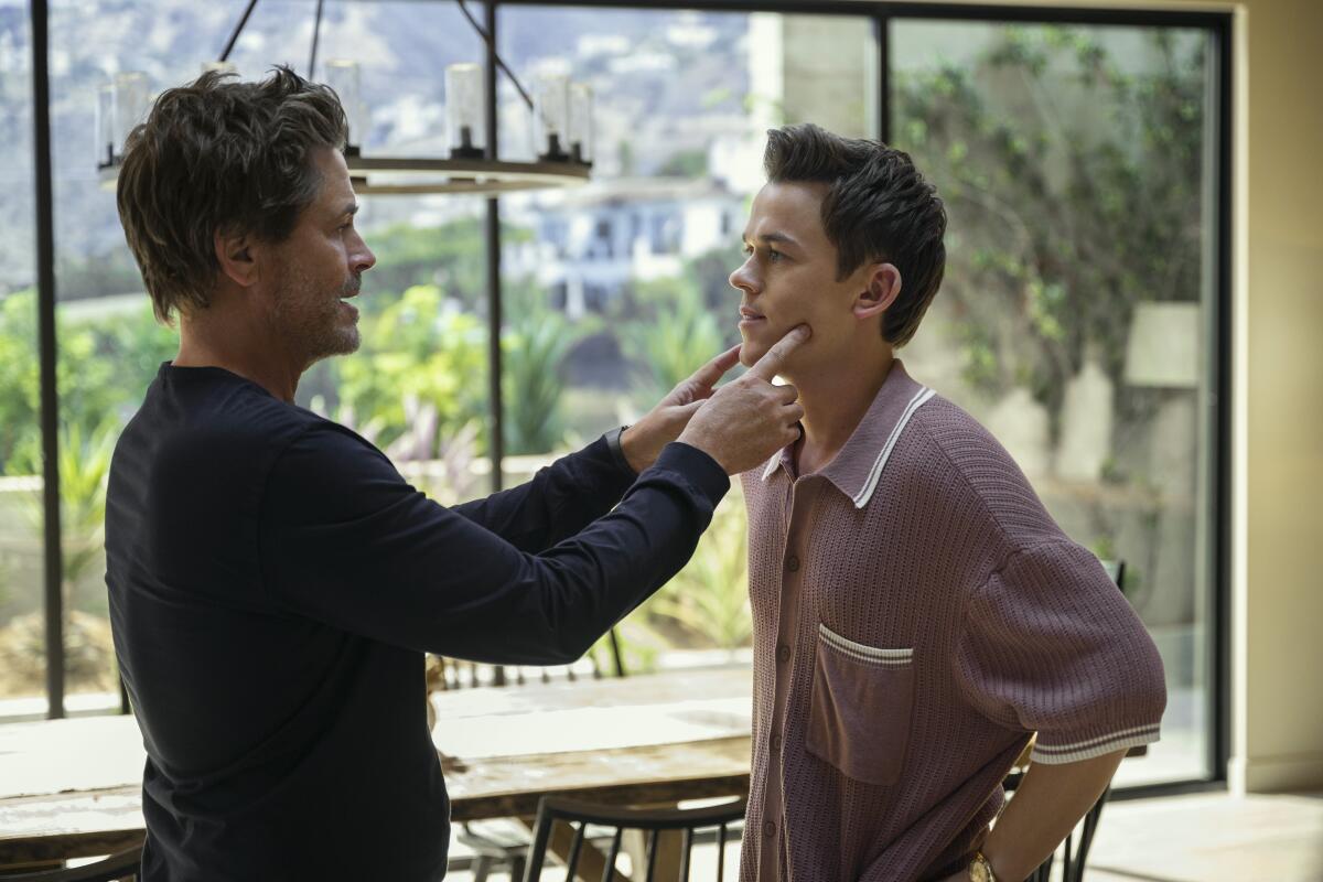 Rob Lowe puts his index fingers on his sons cheeks in a scene from "Unstable."