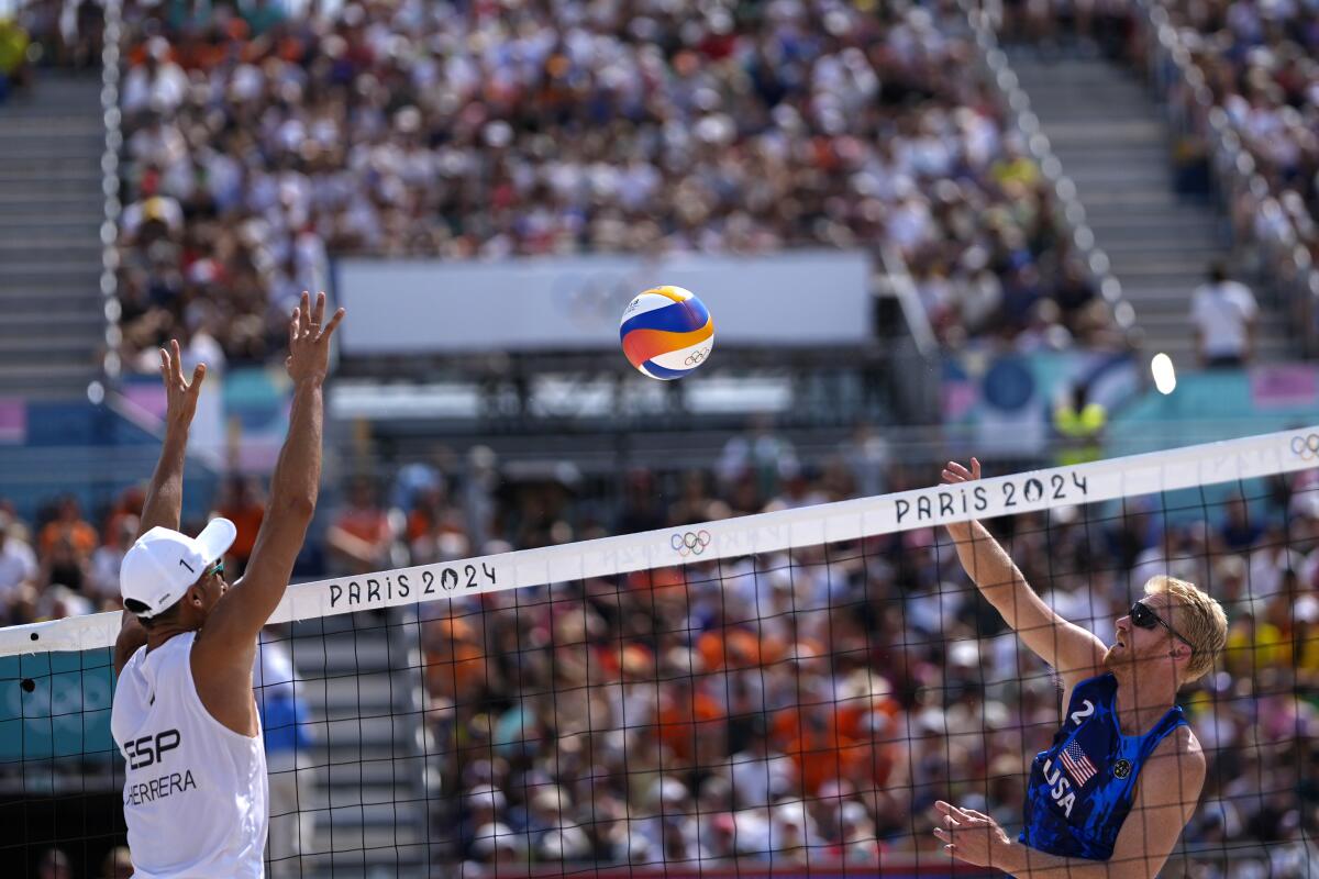 Chase Budinger, right, hits across the net toward Spain's Pablo Herrera Allepuz in a beach volleyball match Friday.