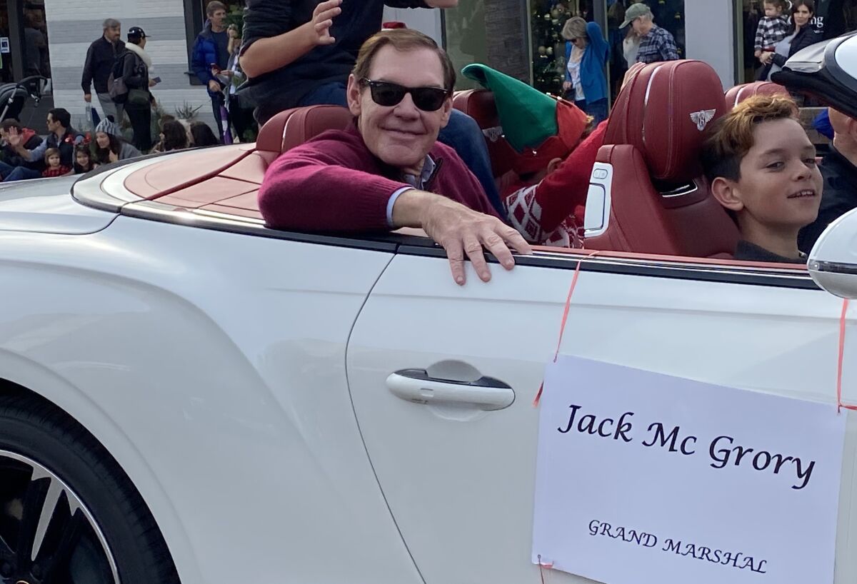 Grand marshal Jack McGrory surveys the parade route from a white Bentley convertible.