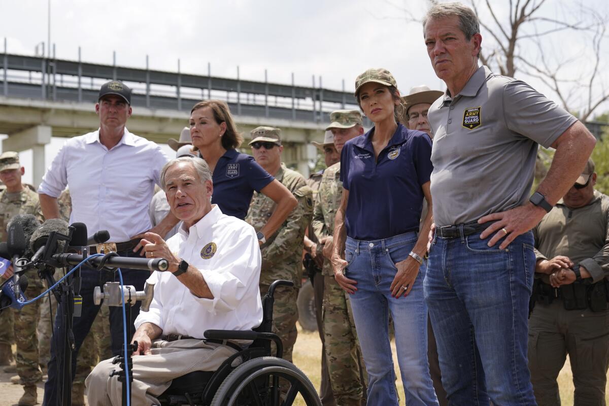 Texas Gov. Greg Abbott, center,