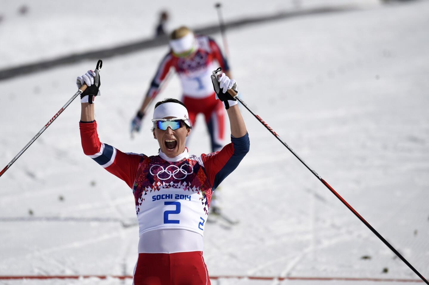 Norway's Marit Bjoergen wins gold as she crosses the finish line in the women's cross-country skiing 30km mass start free.