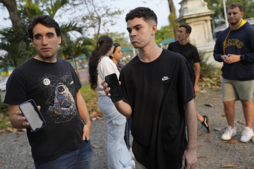 Estudiantes universitarios brasile?os muestran sus celulares luego que la plataforma X fue bloqueada en su país, en Río de Janeiro, el 2 de septiembre del 2024. (Foto AP/Silvia Izquierdo)