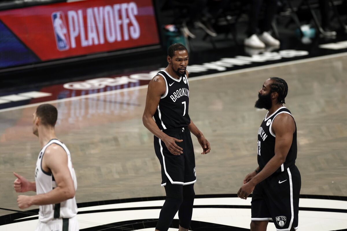 The Nets' James Harden, right, walks off the court past Kevin Durant (7) early in the first quarter June 5, 2021.