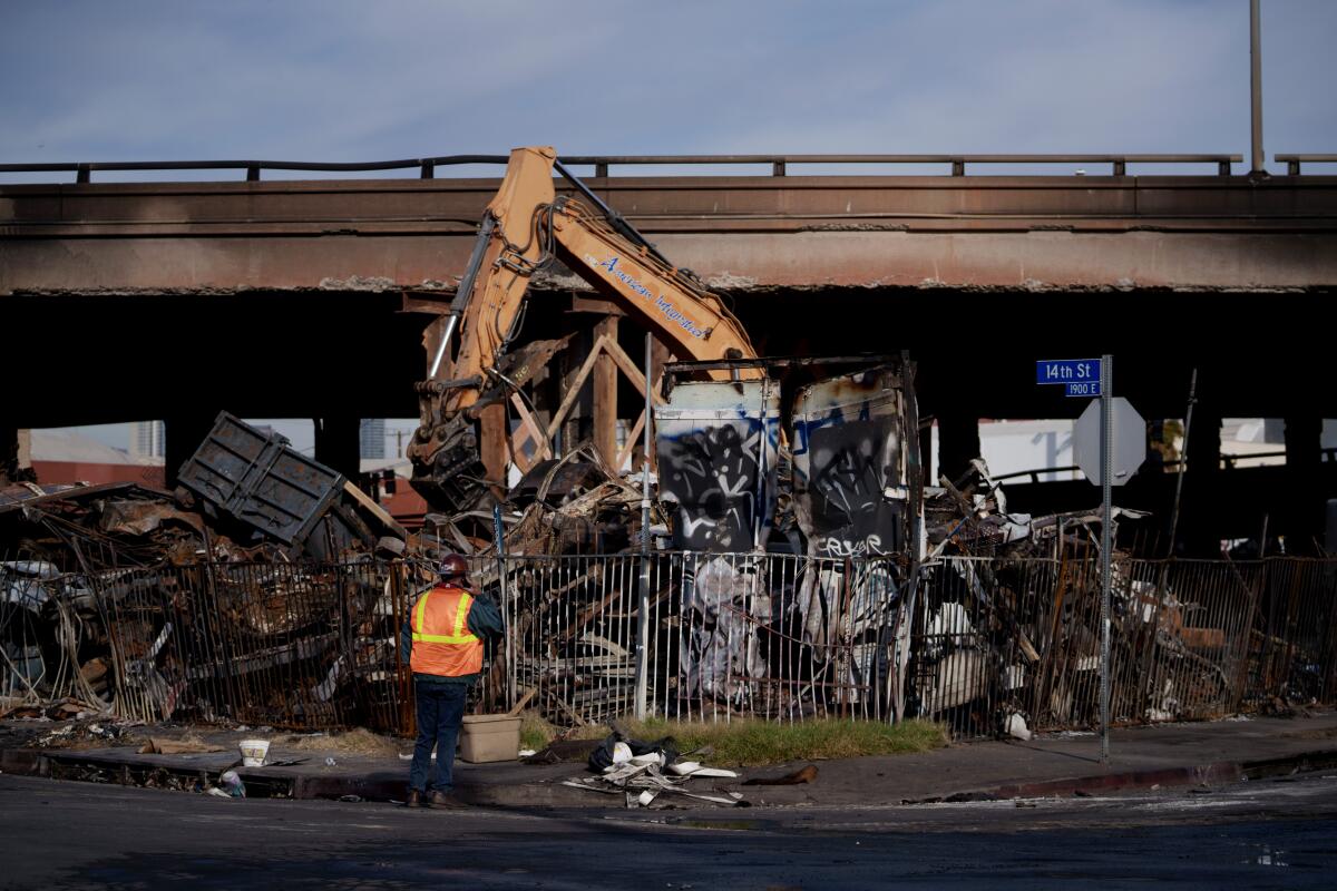 Crews clear debris from the site of a fire under the 10 Freeway in downtown Los Angeles in November.