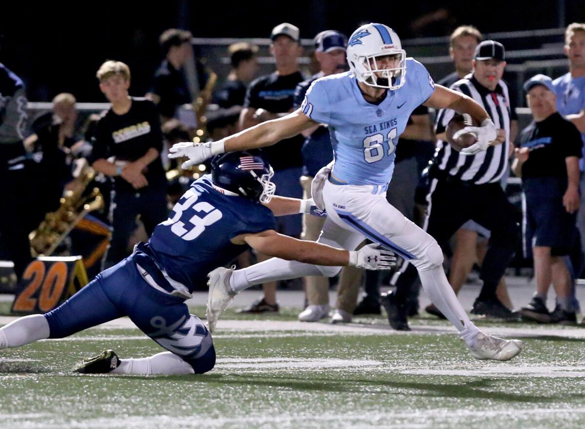 Corona del Mar's Mark Redman (81) avoids a tackle by Newport Harbor's Erik Hehl in the Battle of the Bay rivalry game on Friday at Davidson Field.