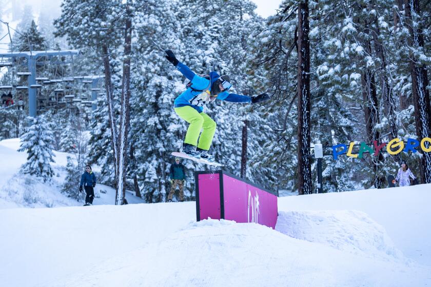 Wrightwood, CA - February 02: Amidst fresh snow from Thursday's storm, a snowboarder jumps off an obstacle in the Playground terrain park at Mountain High Resort in Wrightwood Friday, Feb. 2, 2024. (Allen J. Schaben / Los Angeles Times)