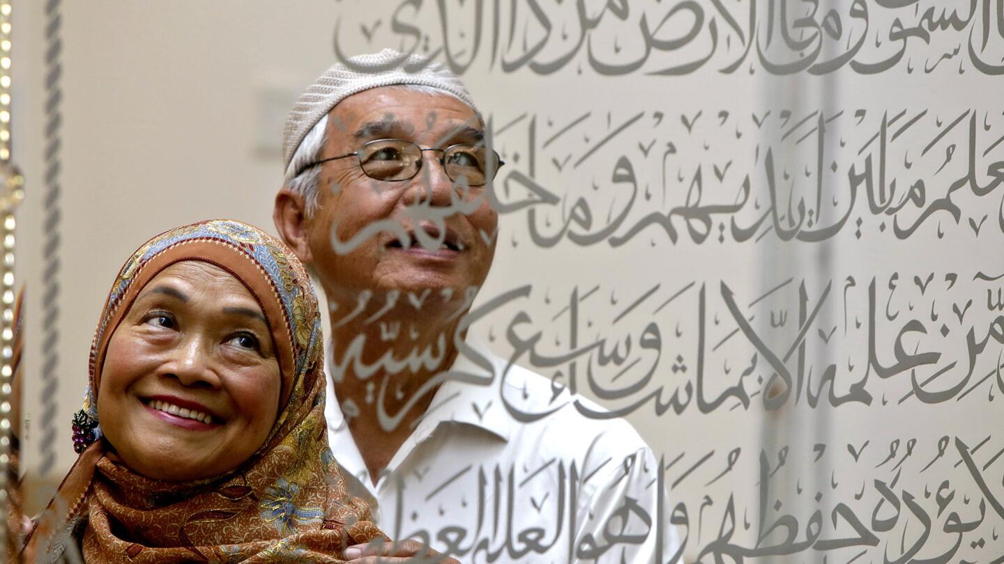 Thai immigrants Rahmat Phyakul, 73, and wife Sukatee, 71, shown reflected in a framed mirror etched with verses from the Koran, started the Masjid Al-Fatiha in Azusa in the late 1990s.