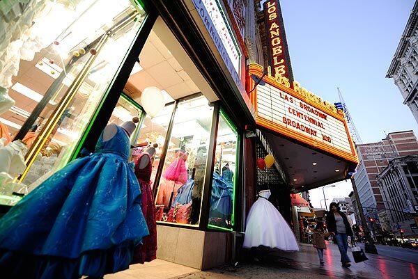 Bright lights illuminate a display of party dresses in the jewelry district of South Broadway. See full story
