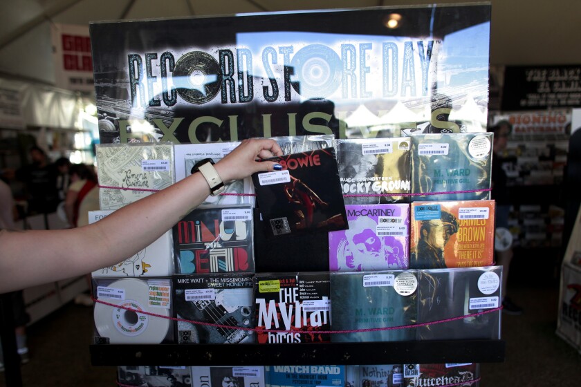 A Zia Records employee pulls a 7" vinyl version of Jimmy Fallon's "Tebowie" at their onsite location on Record Store Day, the second day of week two of the Coachella Valley Music and Arts Festival in 2013.