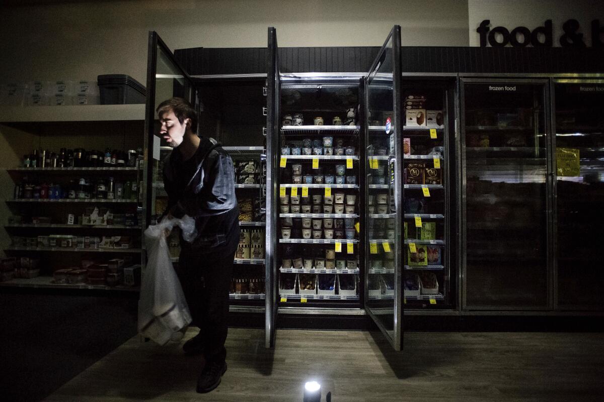 CVS Pharmacy shift supervisor James Quinn throws out ice cream in downtown Sonoma, Calif., during a power outage last month. Pacific Gas & Electric Co. cut power to more than half a million customers in Northern California, hoping to prevent wildfires during dry, windy weather throughout the region.