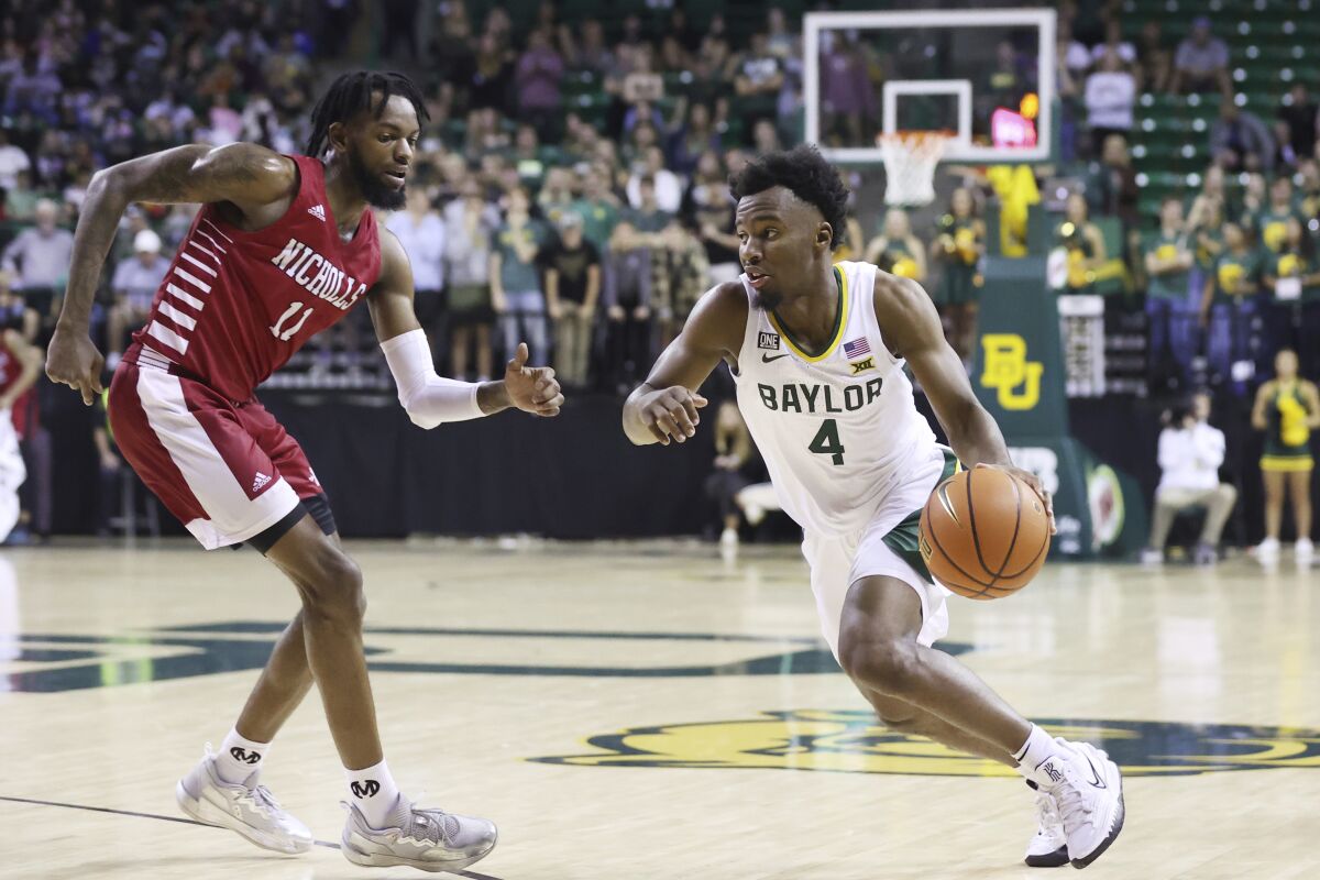 Baylor guard LJ Cryer (4) drives against Nicholls State guard Latrell Jones (11) in the second half of an NCAA college basketball game, Monday, Nov. 15, 2021, in Waco, Texas. (AP Photo/Rod Aydelotte)