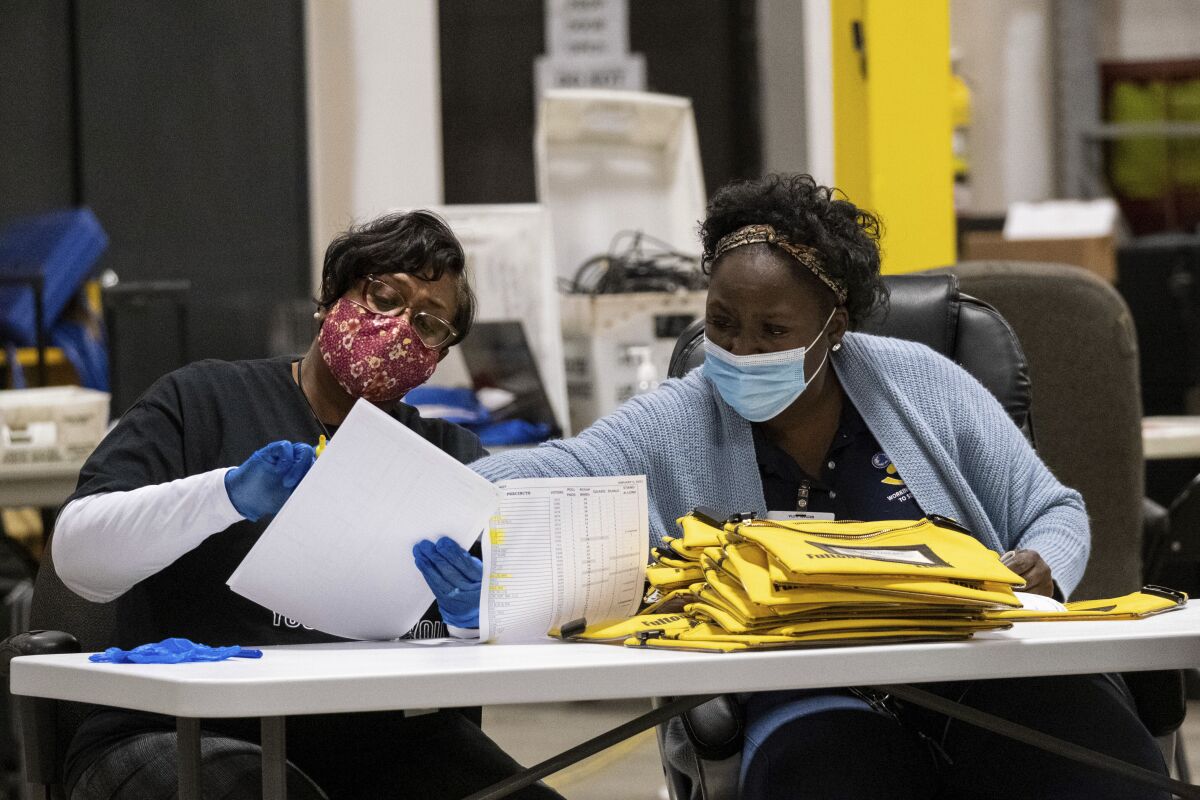 Elections workers consult paperwork