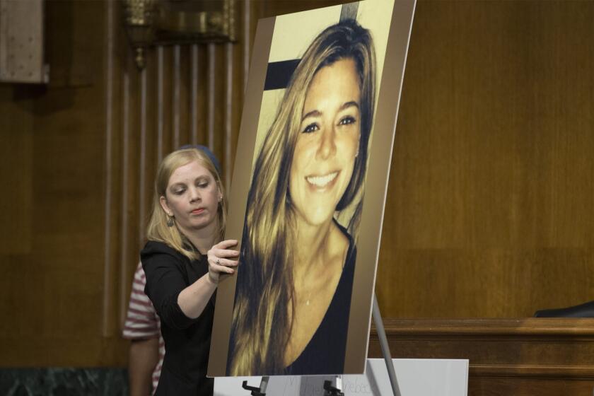 A Congressional staffer puts up a picture of Kathryn Steinle, who was fatally shot in broad daylight on San Francisco's Pier 14 while walking with her father Jim Steinle (not pictured); during Jim Steinle's testimony at a Senate Judiciary Committee hearing July 21.