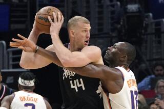 Phoenix Suns center Bismack Biyombo, right, reaches in on Los Angeles Clippers center Mason Plumlee.