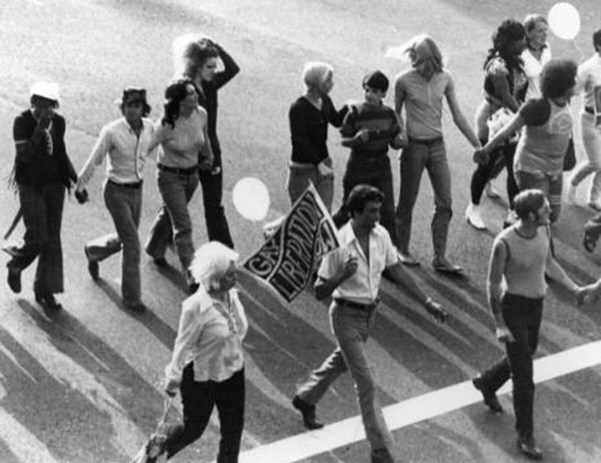 A black and white photo of a Gay Liberation Front contingent at the Los Angeles Christopher Street West pride parade.