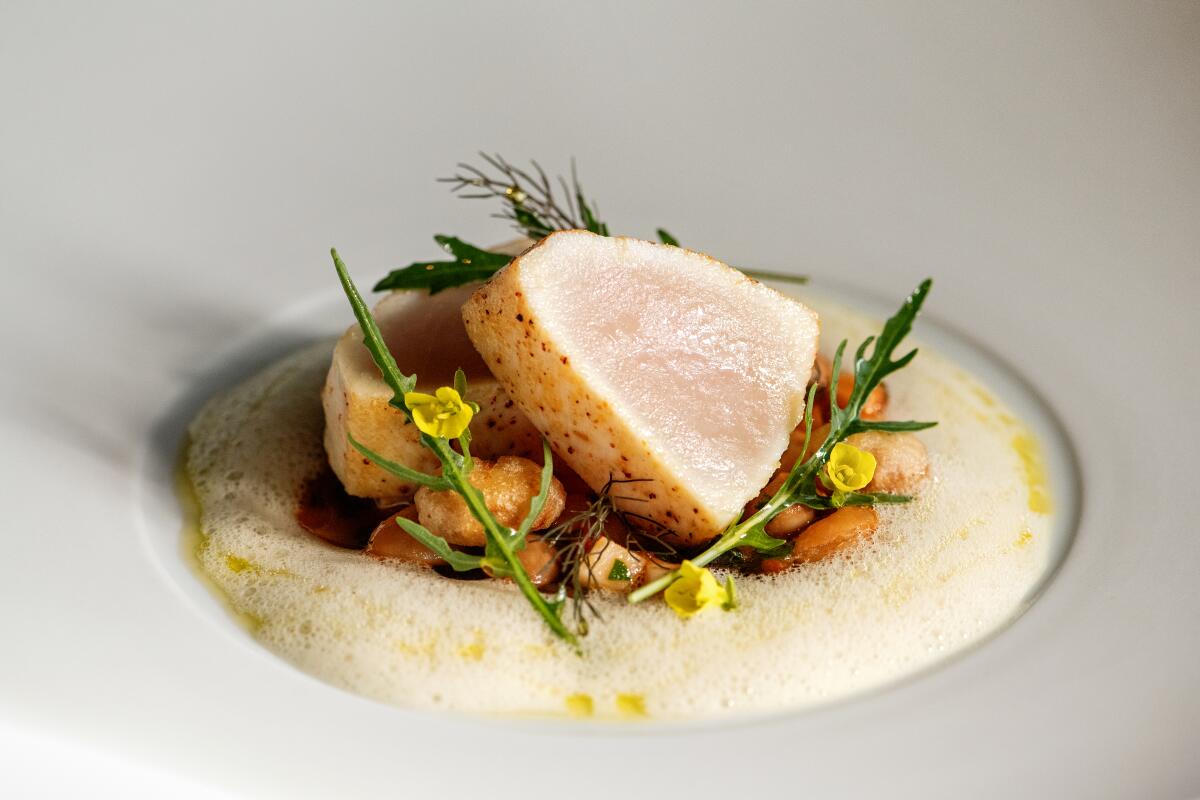 LOS ANGELES, CA - OCTOBER 20: Swordfish: flambo shelling beans, smoked swordfish belly, black winter truffle from Providence on Friday, Oct. 20, 2023 in Los Angeles, CA. (Mariah Tauger / Los Angeles Times)