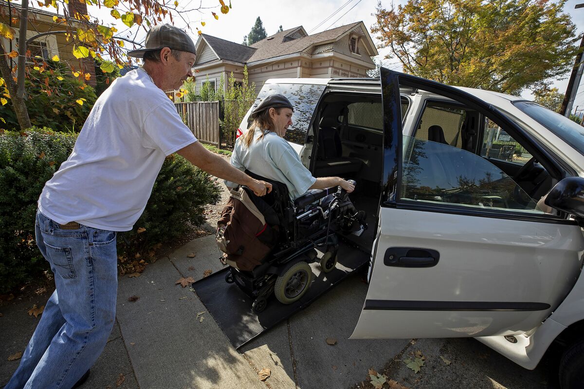 Dirk Collins helps evacuate his brother Darin from their home in Healdsburg, Calif., on Saturday
