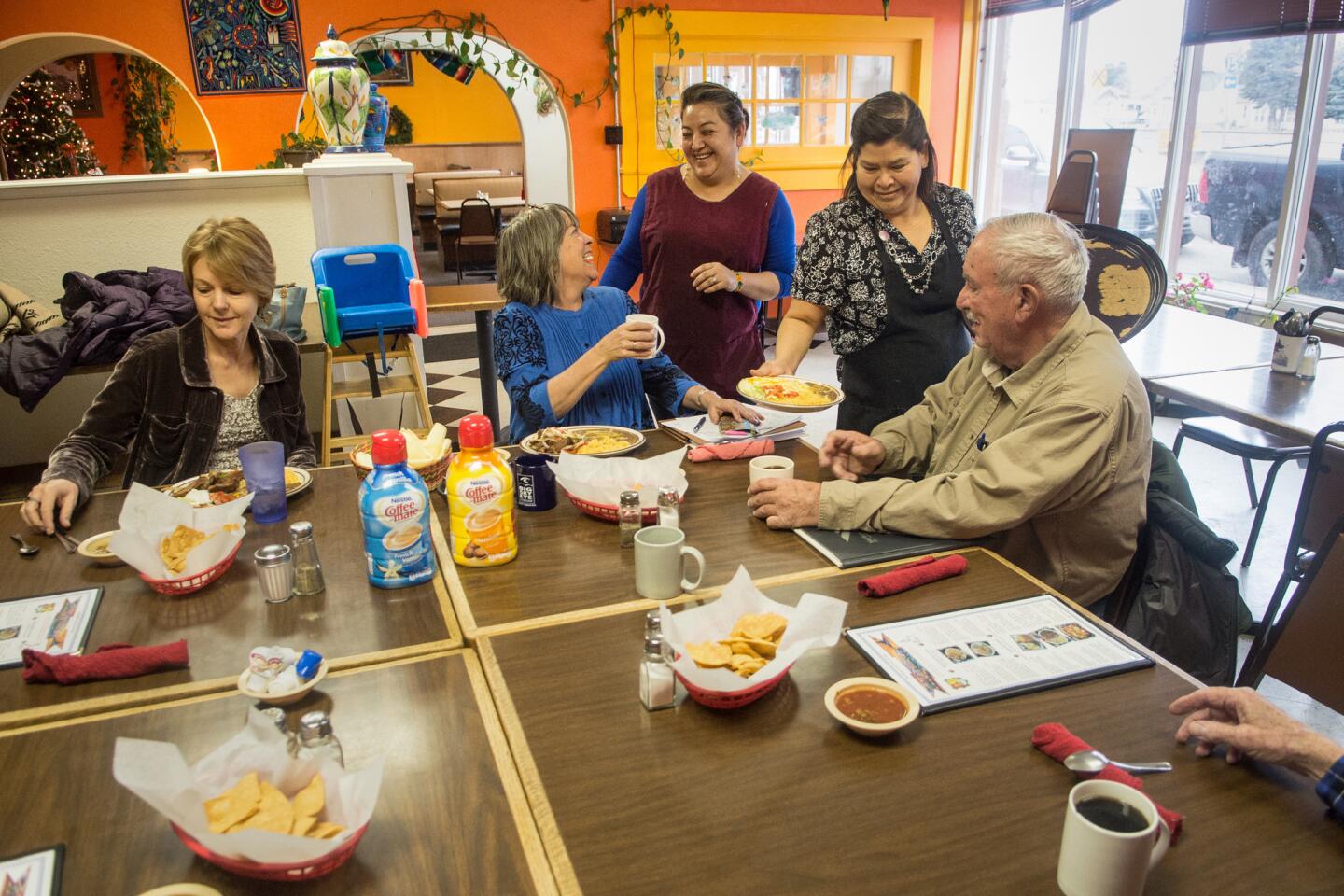Yeni Mora visits with some of her regular customers as Maria Cervantes serves them at Los Koritas, Mora's Mexican restaurant in Dillon, Mont.