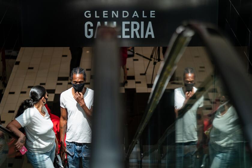 GLENDALE, CA - MAY 28: Wearing masks/face covering and practicing social distancing, people wander the Glendale Galleria on Thursday, May 28, 2020 in Glendale, CA. The Glendale Galleria which has been shuttered to help fight the spread of the novel coronavirus, COVID19, was open today as a result of Gov. Gavin Newsom's easing of requirements for reopening businesses. (Kent Nishimura / Los Angeles Times)