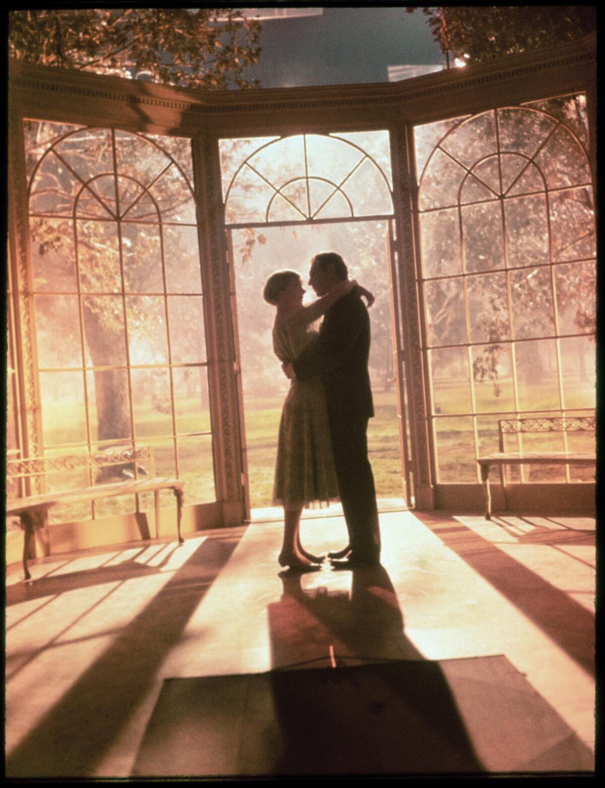 Julie Andrews and Christopher Plummer embrace in "The Sound of Music" (1965) in front of a painted backdrop.