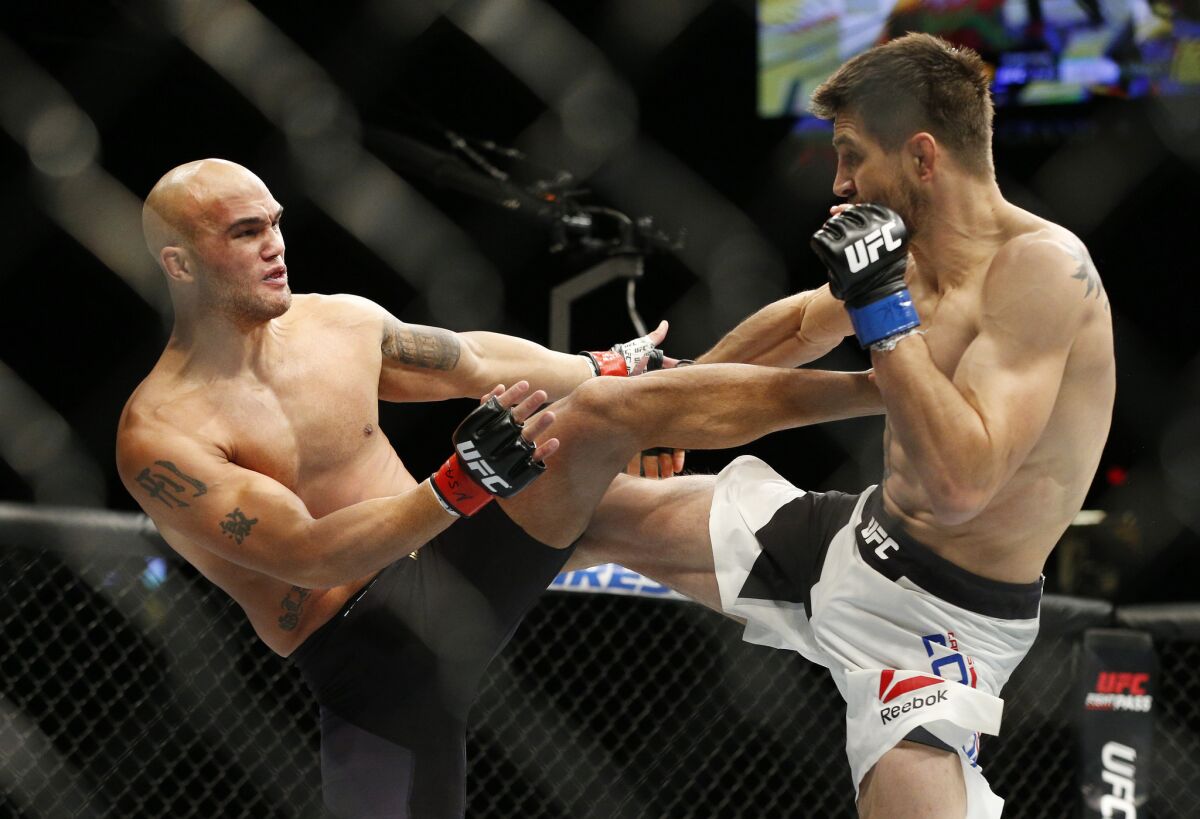 Robbie Lawler, left, and Carlos Condit trade kicks during their welterweight title fight at UFC 195 on Jan. 2.