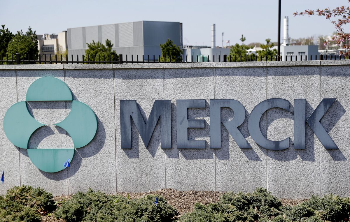 A sign on a wall has Merck's name and logo.