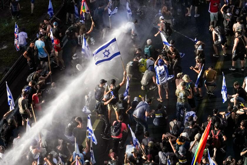 Israeli police use a water cannon to disperse demonstrators blocking a road during a protest against plans by Prime Minister Benjamin Netanyahu's government to overhaul the judicial system, in Jerusalem, Monday, July 24, 2023. Israeli lawmakers on Monday approved a key portion of Prime Minister Benjamin Netanyahu's divisive plan to reshape the country's justice system despite massive protests that have exposed unprecedented fissures in Israeli society. (AP Photo/Mahmoud Illean)