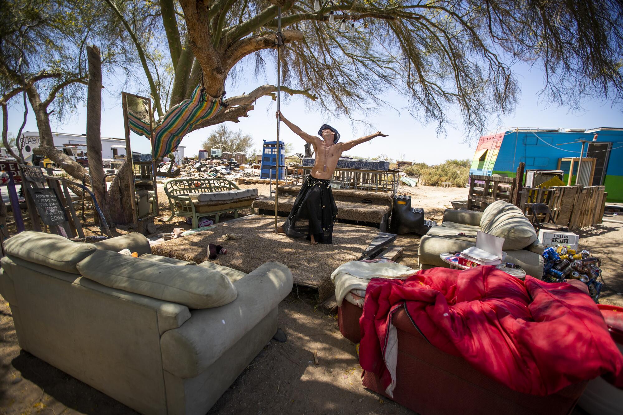 Wearing a cowboy hat, artist Peter Passalacqua spins around on a pole on the dance floor at his sprawling slab