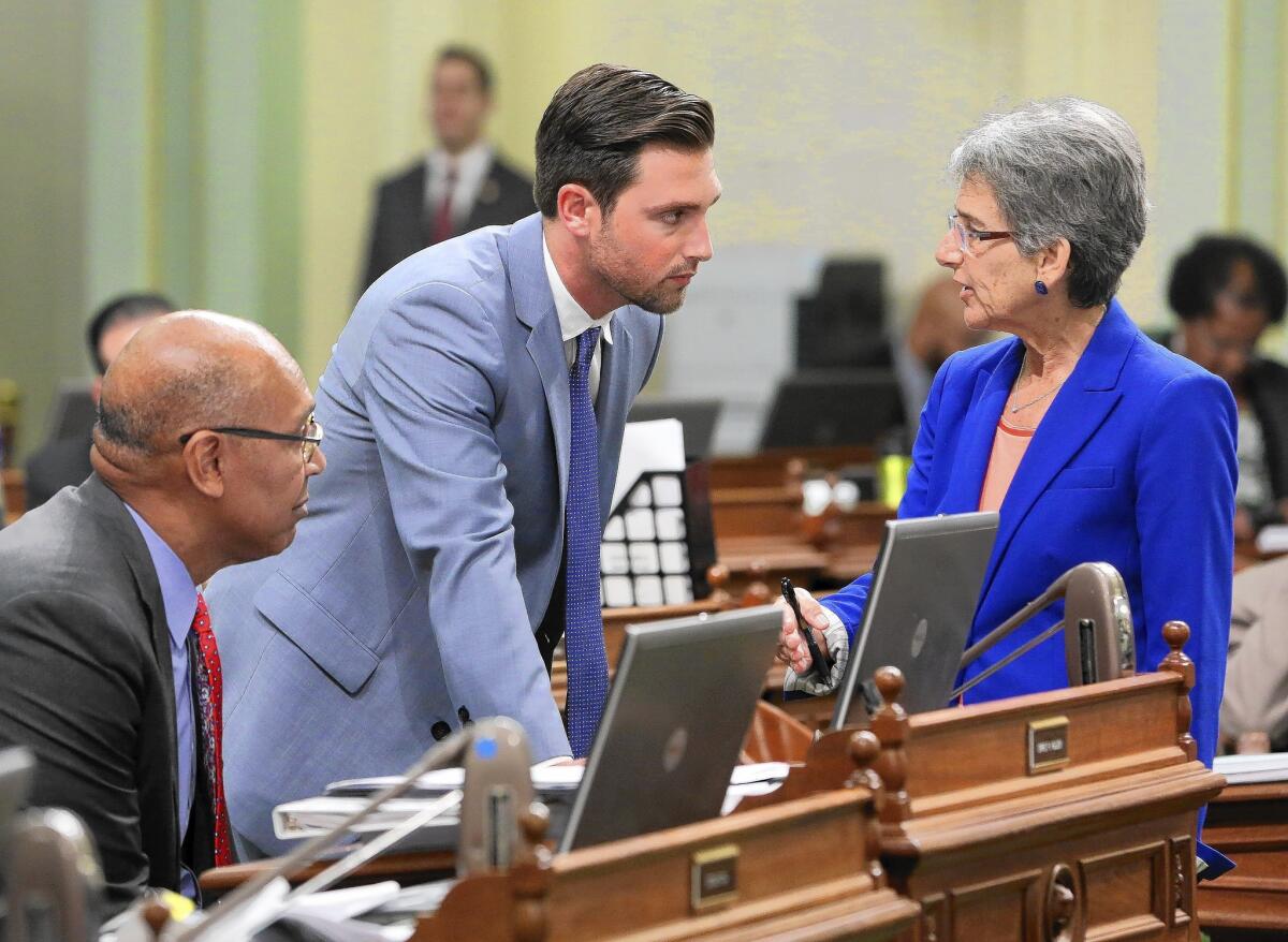 State Sen. Hannah-Beth Jackson (D-Santa Barbara) talks with Assemblyman Ian Charles Calderon (D-Whittier) about voting for her franchise agreement measure Aug. 14 at the Capitol in Sacramento. Assemblyman Chris Holden (D-Pasadena) is at left.