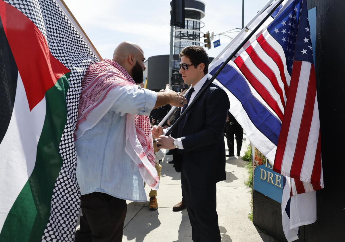 An Israel supporter stands on the sidewalk as a pro-Palestinian protester shares his views.