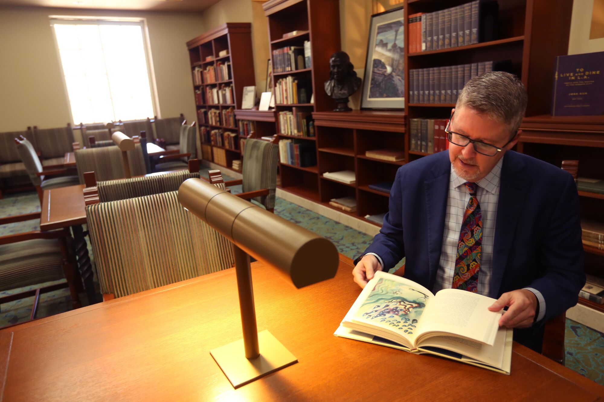 City Librarian John Szabo looks over a copy of the 150th Anniversary Edition of Alice's Adventures in Wonderland.