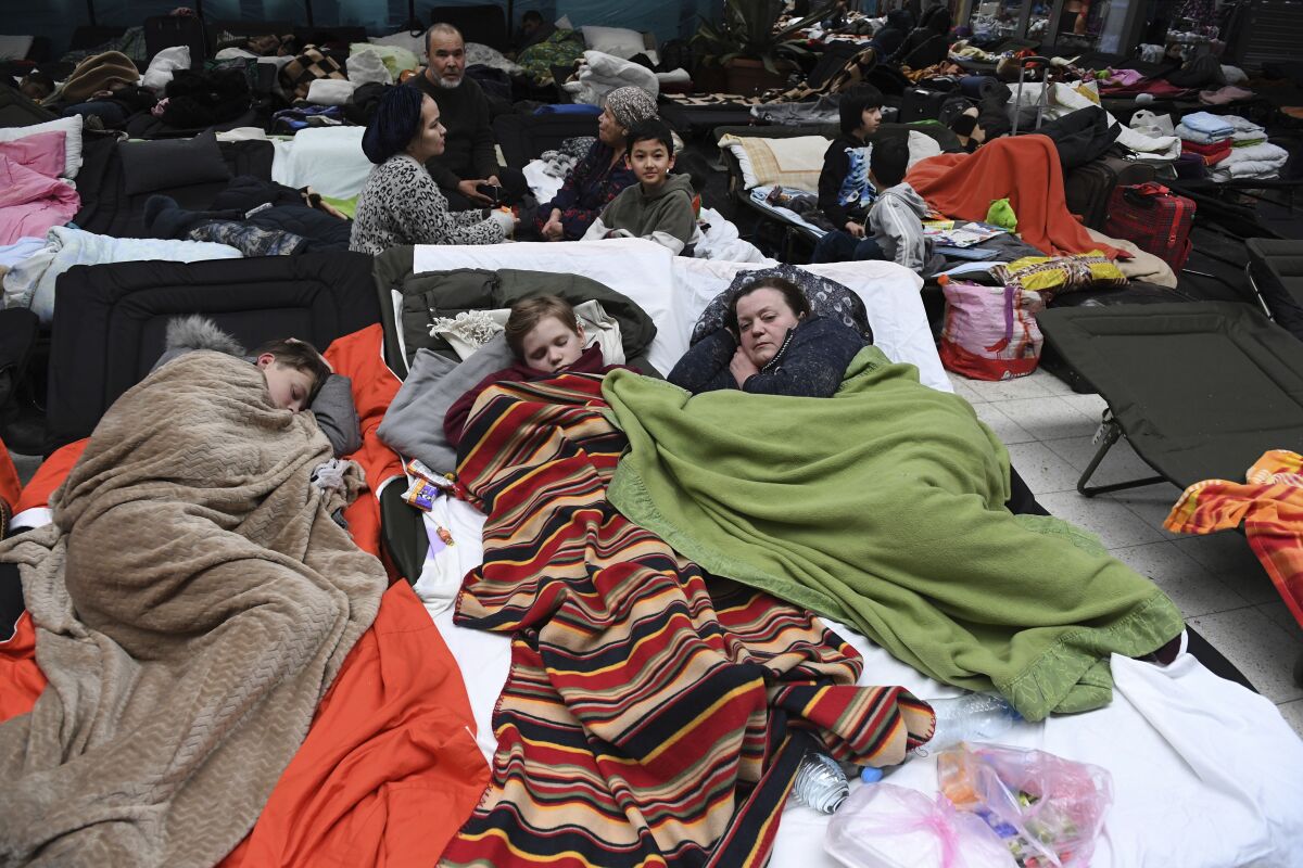 People sleep on cots, at a reception center for displaced persons from Ukraine, at the Ukrainian-Polish border crossing in Korczowa, Poland, Saturday, March 5, 2022. U.S. Secretary of State Antony Blinken toured the center on Saturday with Polish officials. (Olivier Douliery, Pool Photo via AP)