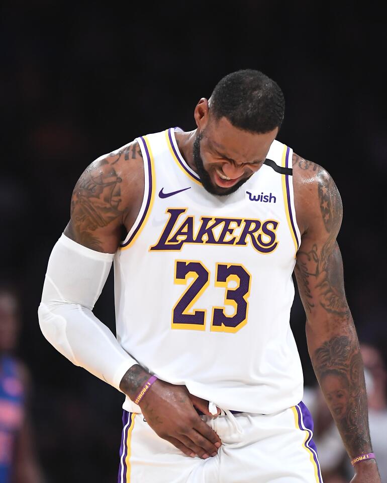 Lakers star LeBron James grimaces in pain during the second quarter against the Detroit Pistons.