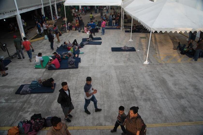 Integrantes de la caravana de migrantes hoy, domingo, en el punto fronterizo de Tecún Umán (Guatemala), en espera de un contingente mayor para cruzar a territorio mexicano. EFE