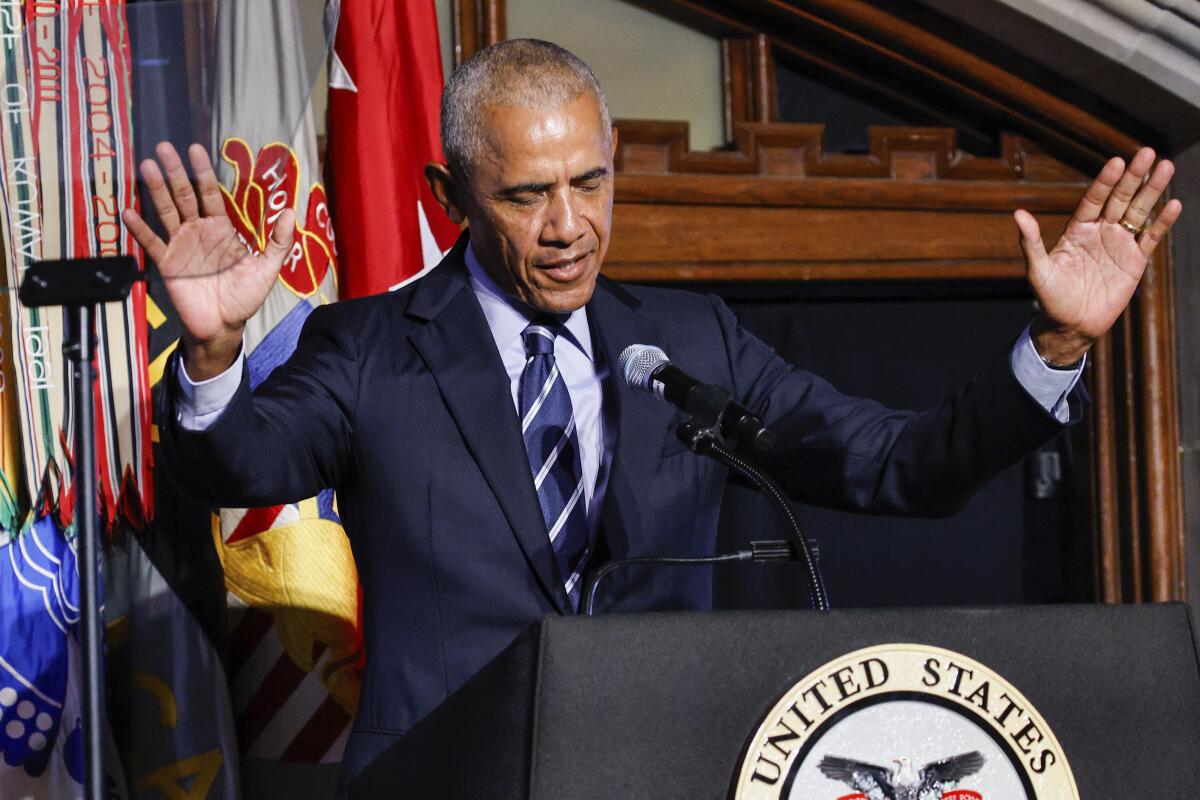 Former President Obama holding his hands up as he speaks