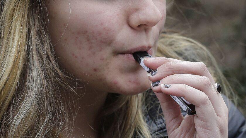 A high school student uses a vaping device in Cambridge, Mass. The proportion of high school seniors who are vaping tobacco products nearly doubled in the past year, according to a new report.