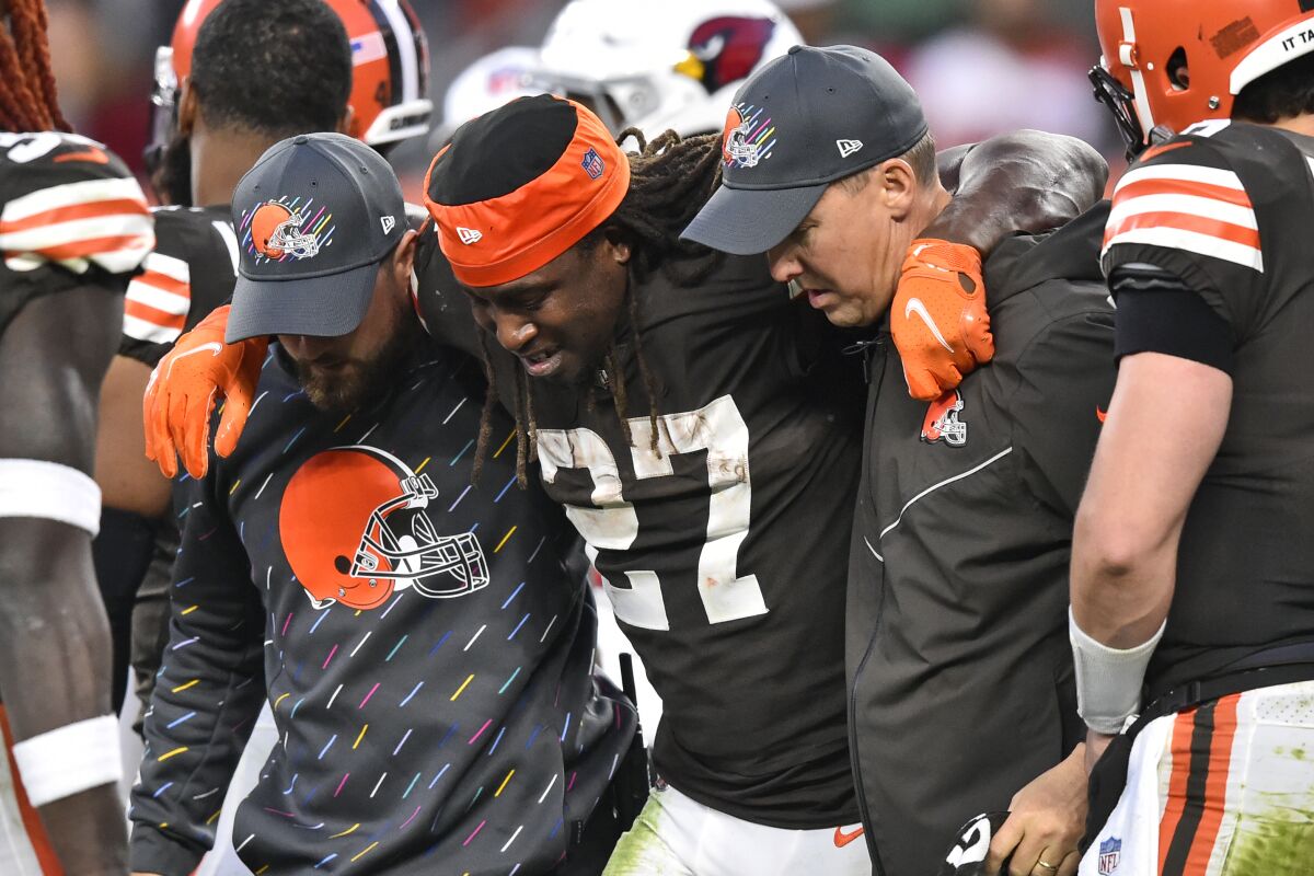 Cleveland Browns running back Kareem Hunt (27) is helped off the field after an injury during the second half of an NFL football game against the Arizona Cardinals, Sunday, Oct. 17, 2021, in Cleveland. (AP Photo/David Richard)