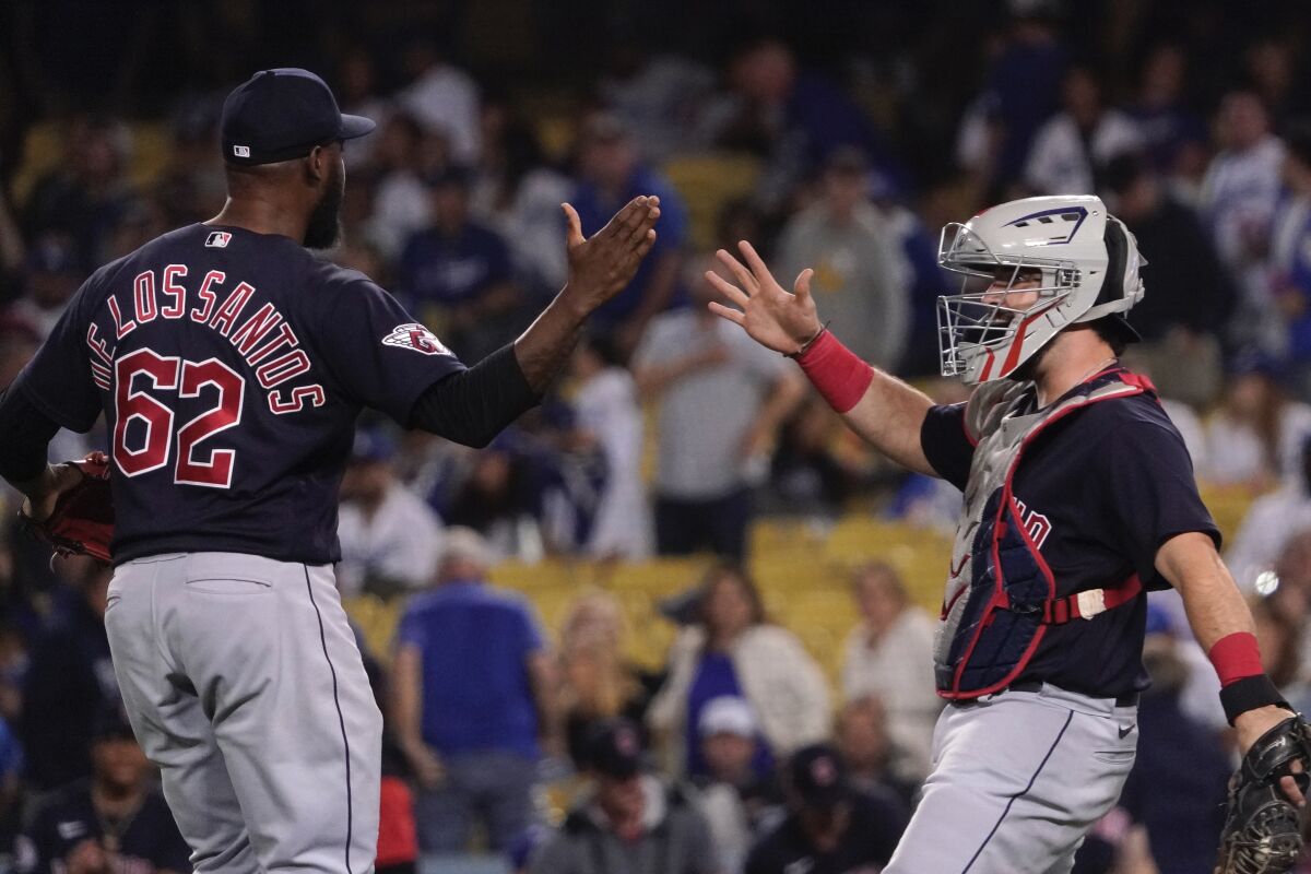 Cleveland Guardians relief pitcher Enyel De Los Santos, left, and catcher Luke Maile congratulate each other after the Guardians defeated the Los Angeles Dodgers 2-1 in a baseball game Friday, June 17, 2022, in Los Angeles. (AP Photo/Mark J. Terrill)