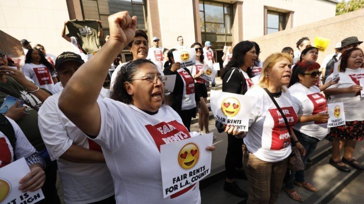 Maria Leon, left, from East Los Angeles joins crowd on steps of County Hall of Administration Tuesday to urge Supervisors to extend a cap rent increases through 2019.