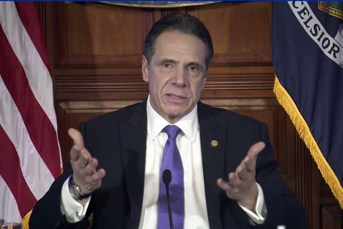 Andrew Cuomo lifts his hands as he speaks
