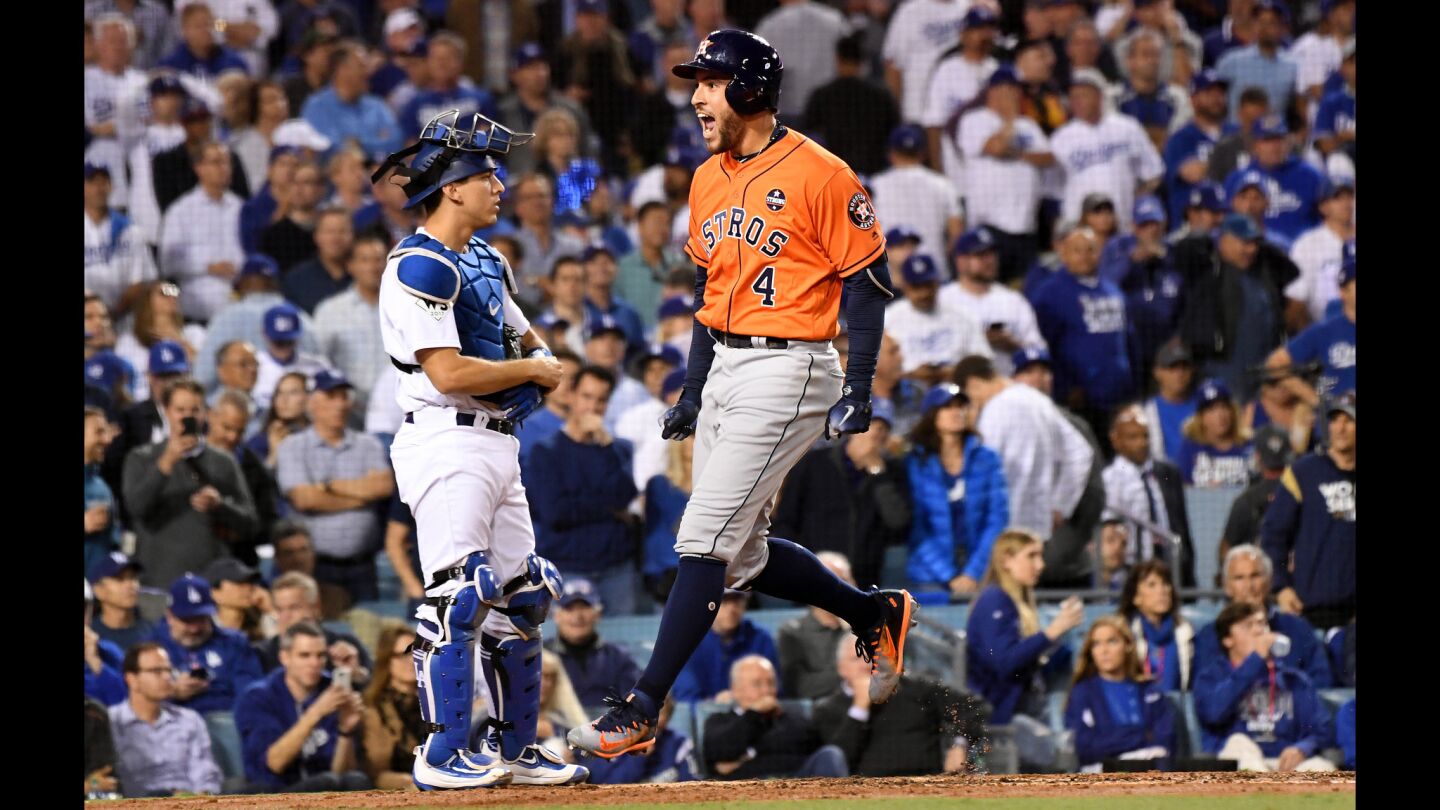 The Astros' George Springer reaches home in front of Dodgers catcher Austin Barnes after hitting a two-run home run in the second inning.