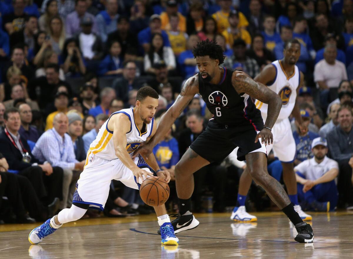 Clippers center DeAndre Jordan (6) tries to guard Warriors star Stephen Curry (30) on the perimeter in the first half.